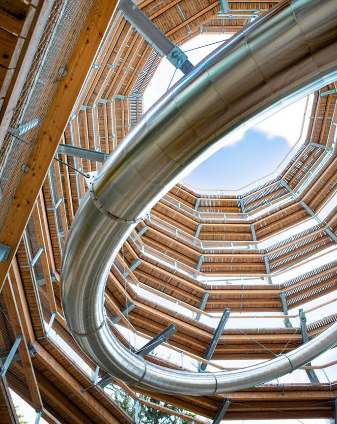 Pohled do interiéru vyhlídkové věže s integrovnou tunelovou skluzavkou, moderní architektura.