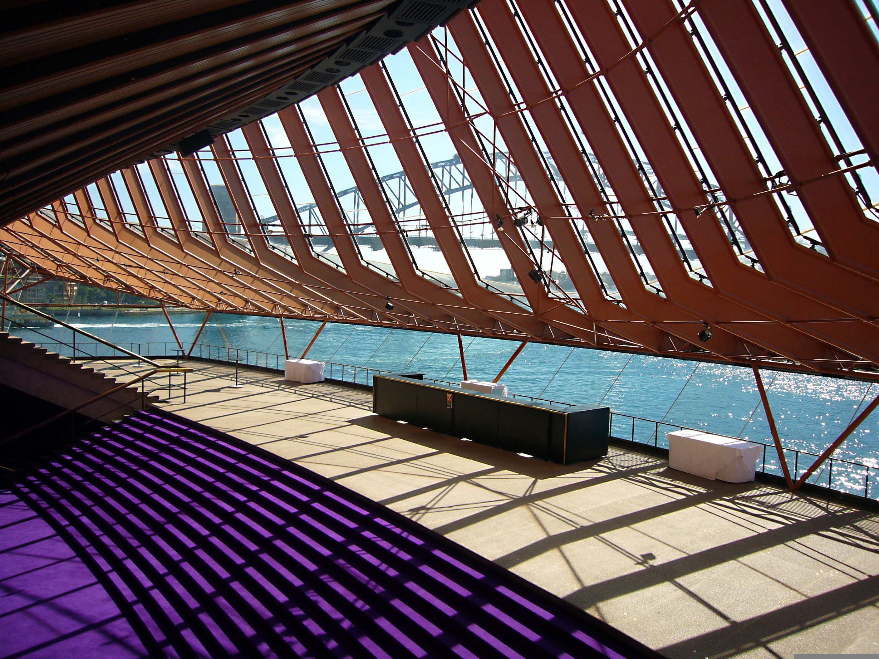 Detailní pohled na architektonickou konstrukci pod ikonickými plachtami opery v Sydney.