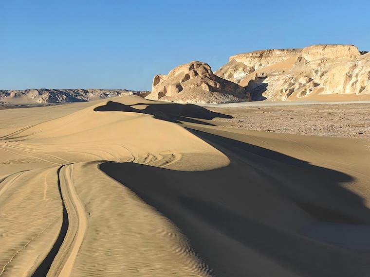 Eine weite Wüstenlandschaft in Ägypten, erstreckt sich bis zum Horizont.