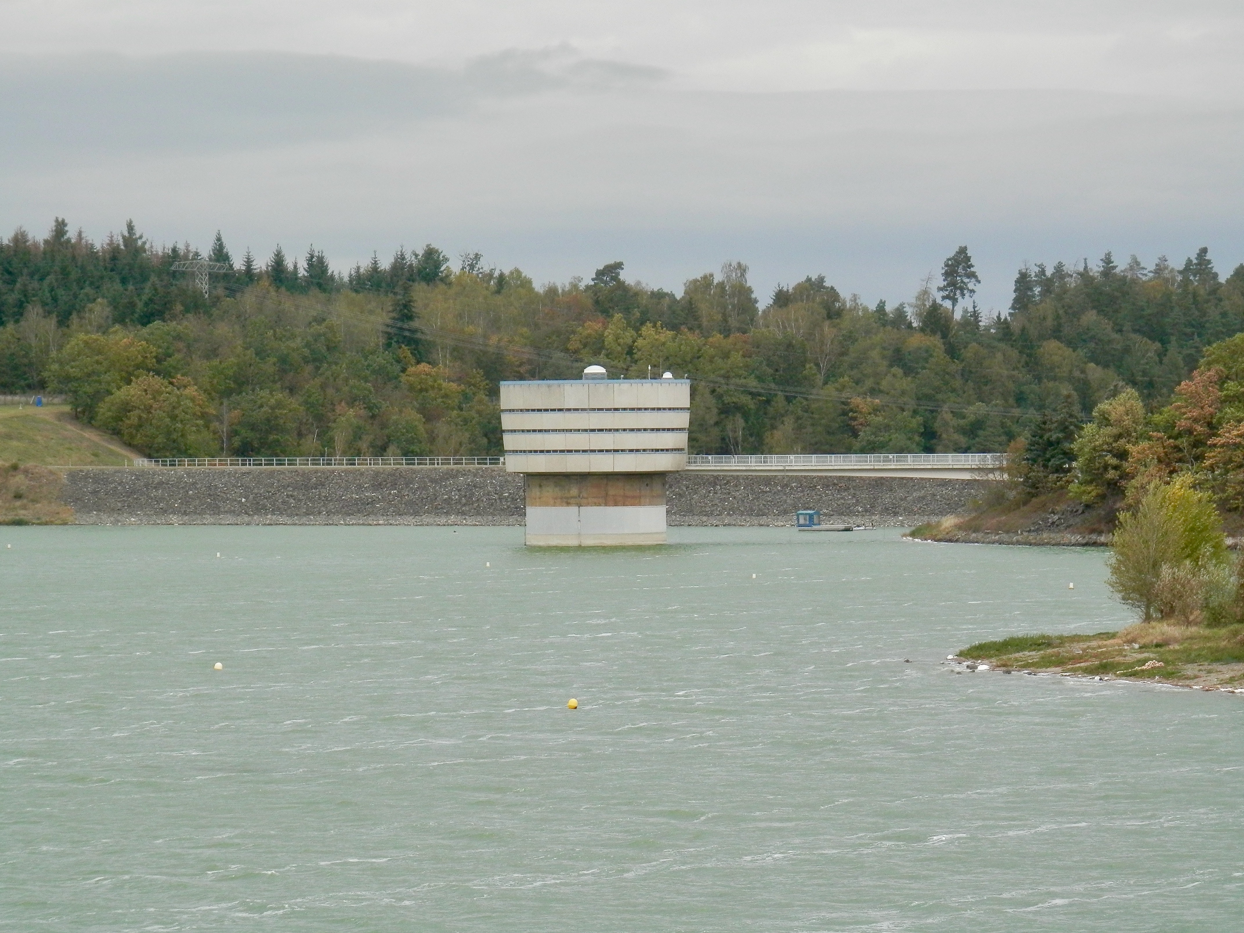 Ansicht der Talsperre Zeulenroda, eingebettet in die umgebende Landschaft, mit Wasserreservoir im Vordergrund.