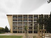 Seitenansicht eines Universitätsgebäudes aus Holz, das durch sein modernes und nachhaltiges Design besticht und Teil eines innovativen Architekturprojekts ist.