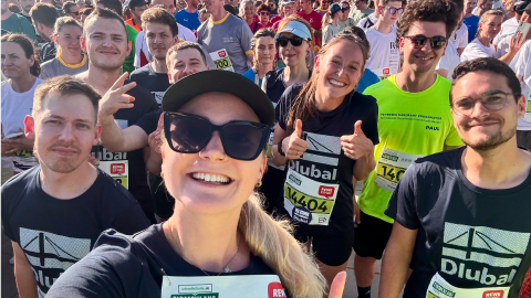 Eine vielfältige Gruppe von Kollegen steht gemeinsam für ein Teamfoto bei einem Firmenevent oder einer Teambuilding-Aktivität zusammen.