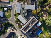 Luftaufnahme der Grundschule Otzenrath in Hybridbauweise mit metalldachgedeckten Bauteilen, begrüntem Flachdach im Rohbau und umgebendem Wohngebiet