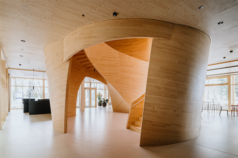 Foyer of Blumer Lehmann Headquarters in Gossau, Switzerland, featuring a curved atrium staircase resembling a tree trunk.