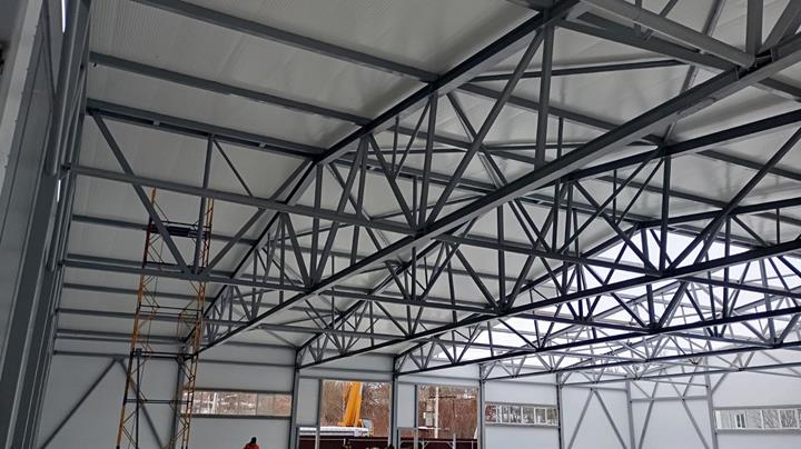 Detailed view of the supporting structure of a hall roof with steel trusses and connecting elements