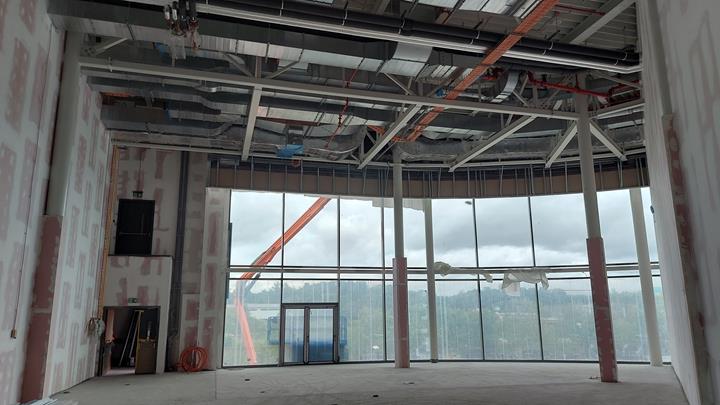 Structure of a steel extension to a shopping mall with a flat roof and skylight.