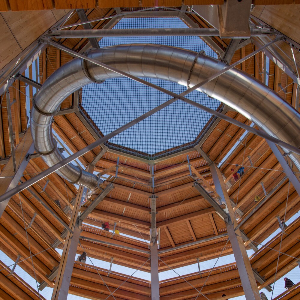 The interior view of the lookout tower shows a spiral-shaped timber structure.