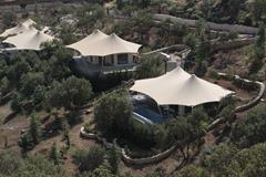 Steel membrane roof structures in a picturesque mountain landscape.