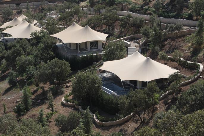 Steel membrane roof structures in a picturesque mountain landscape.