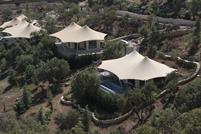 Steel membrane roof structures in a picturesque mountain landscape.