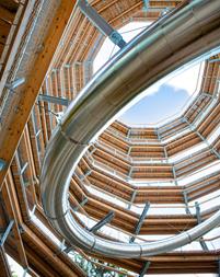Interior view of a lookout tower with an integrated tunnel slide, modern architecture.