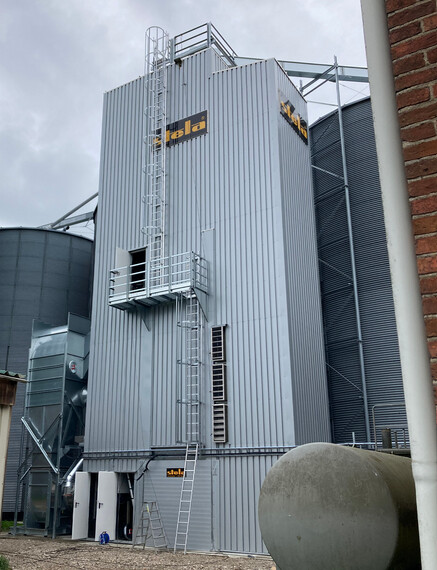 Steel structure of a grain drying tower with modern design elements.