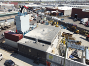 Aerial view of a concrete mixing plant during installation, surrounded by construction activity.