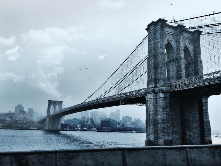 The Brooklyn Bridge connects Manhattan and Brooklyn and is an iconic structure in New York, designed by John Augustus Roebling.