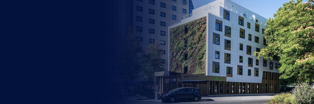 Modern façade of the Hôtel Mercure Paris Porte de Pantin, located on the outskirts of Paris, with glass and concrete structures.