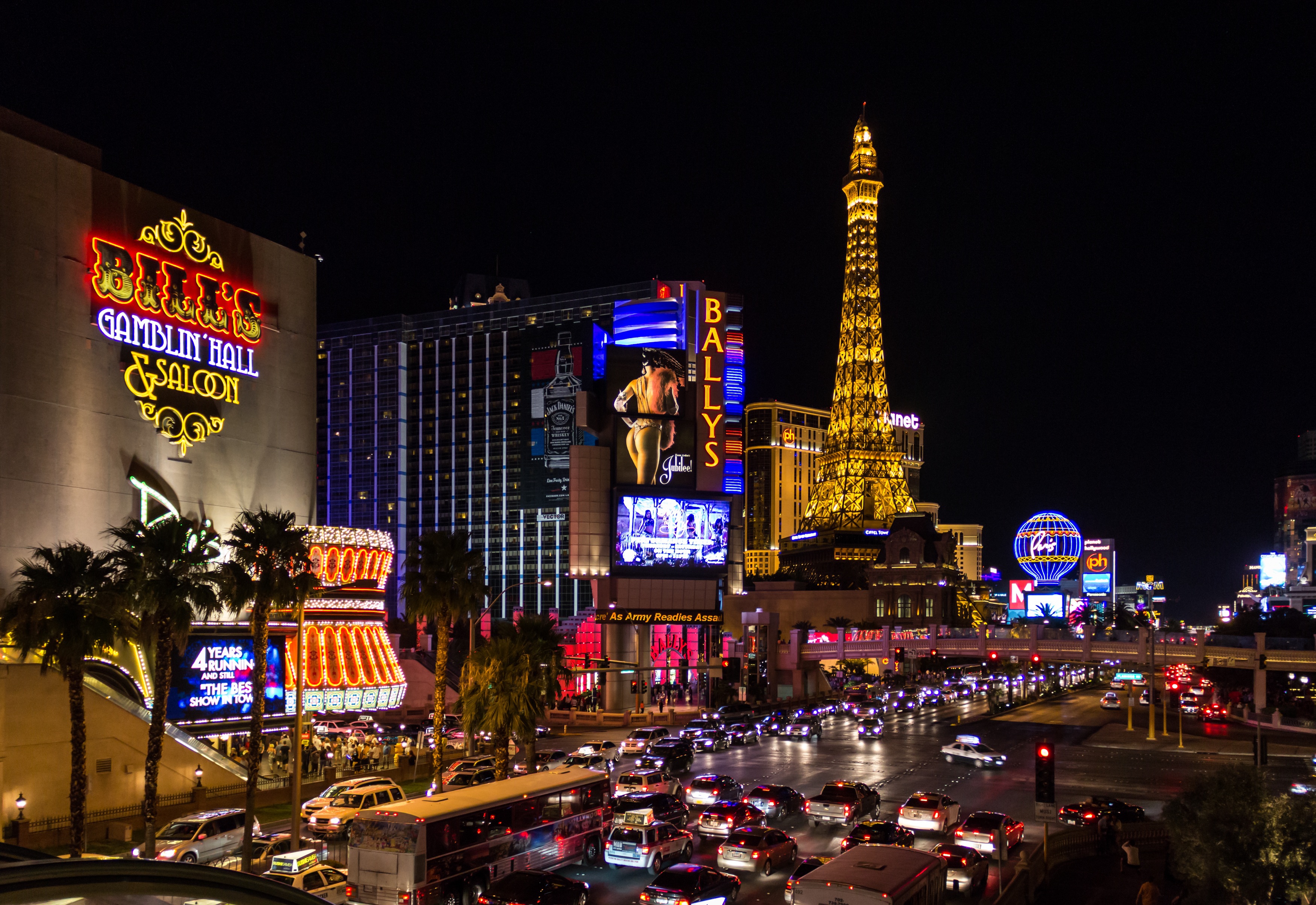 A street scene in Las Vegas full of colorful lights and neon signs at night.
