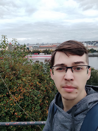 Ivan Maltsev, new member of the Dlubal Software AI team, outdoors with a cityscape in the background.