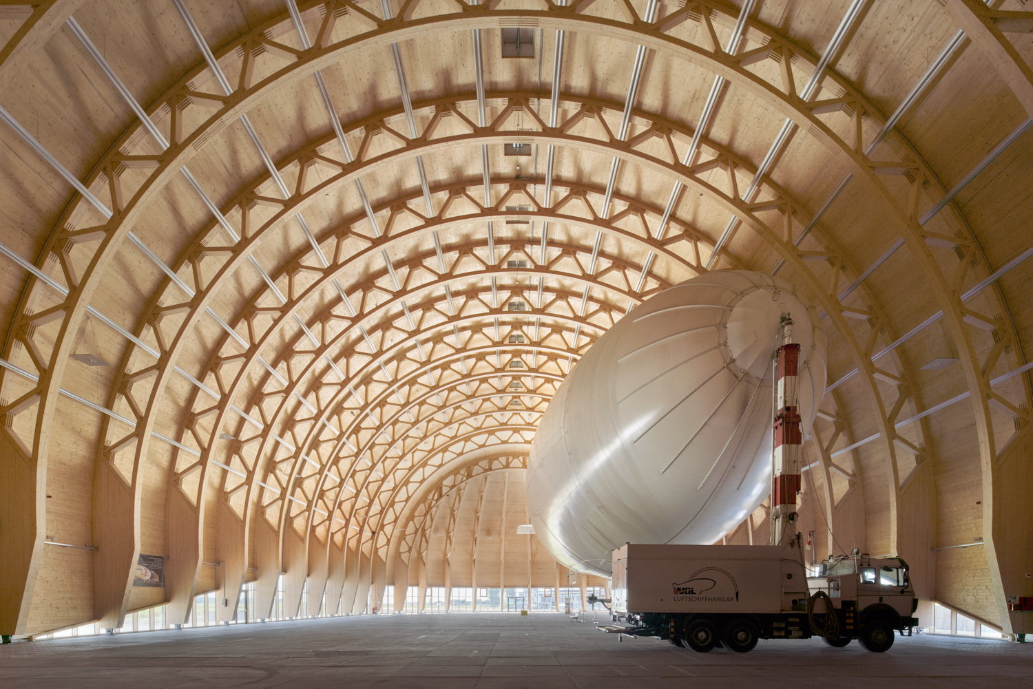 Hangar de dirigibles sostenible en Mühlheim con estructura portante de madera y cimientos reciclados, iluminación natural
