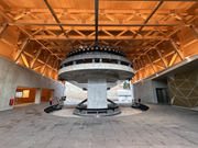 Vista interior de la estación base con teleféricos 3S, estructura de acero, cubierta de madera y losa de hormigón
