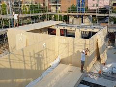 Sitio de construcción de un edificio de 6 pisos de CLT en Módena, Italia, mostrando elementos estructurales y el entramado.