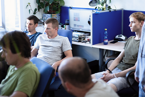 Equipo de desarrollo de software con intensa concentración hablando sobre detalles del proyecto en un espacio de trabajo común