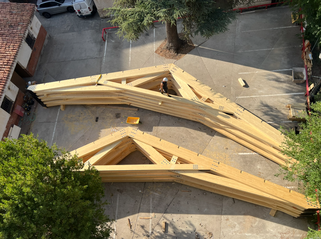 Cerchas en tijera de madera dispuestas para instalación en una obra.