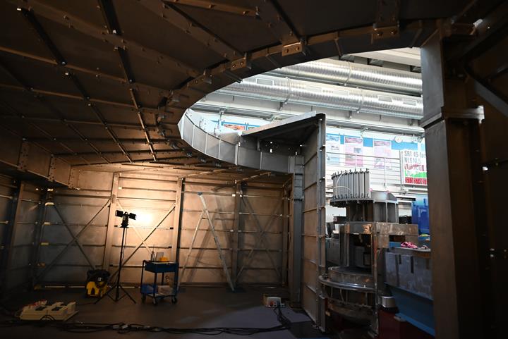 Vista interior de una pantalla de estructura de acero en un campo experimental. La robusta construcción de acero ofrece una estética moderna de aspecto industrial.