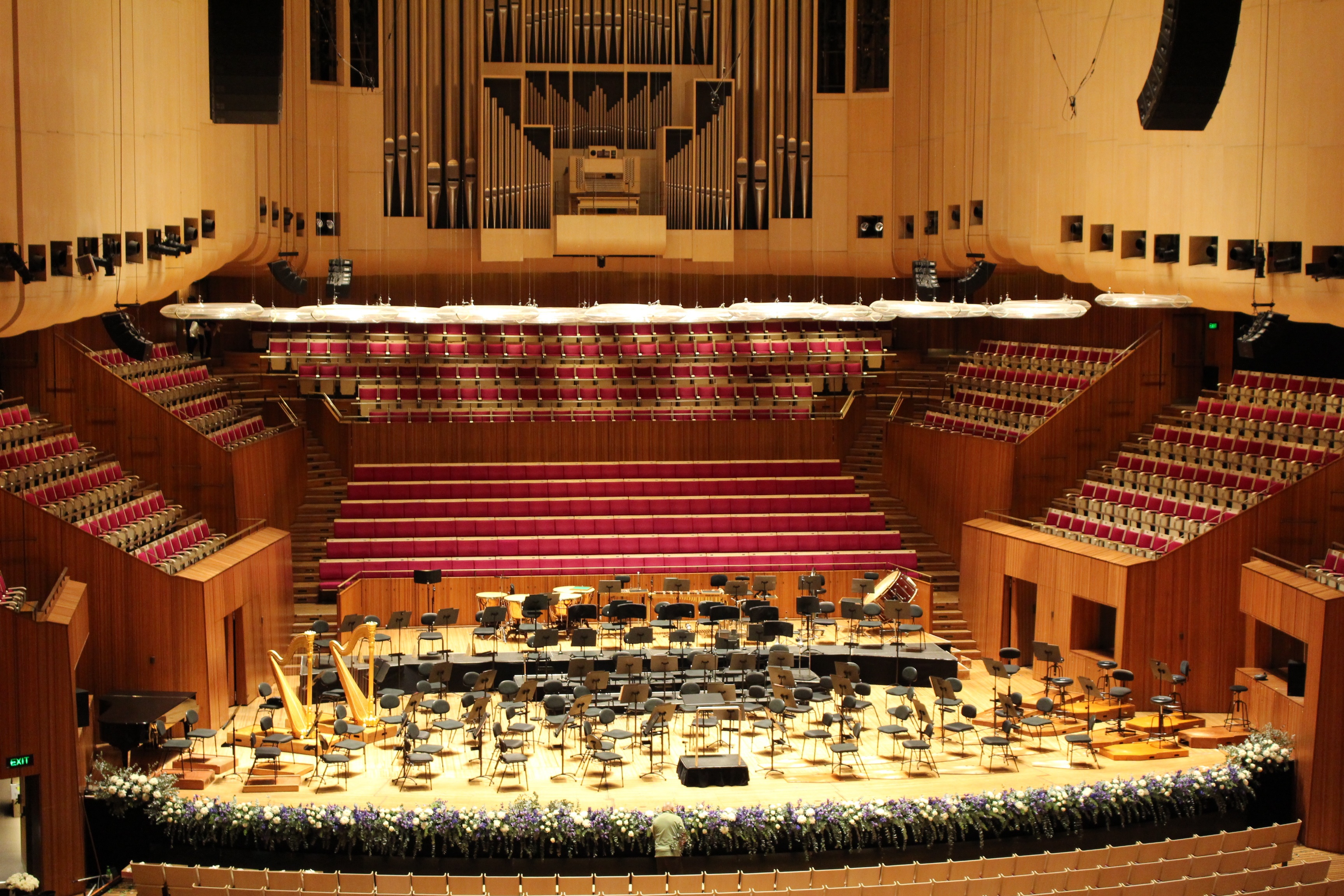 Vista interior de la sala de conciertos de la Ópera de Sídney con arquitectura acústica moderna.
