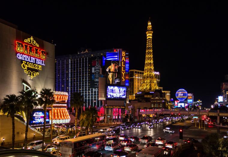 Carretera escena de Las Vegas llena de luces de colores y letreros de neón por la noche.