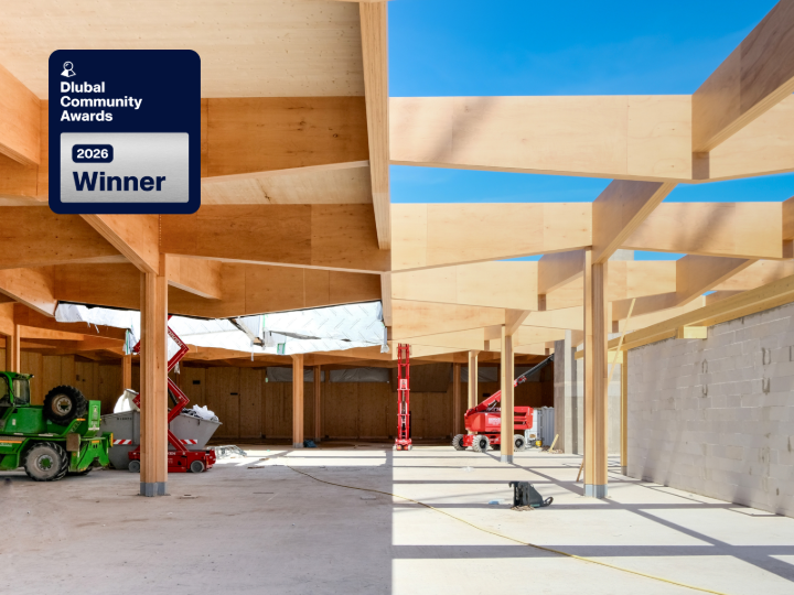Rejilla de vigas de madera de madera microlaminada de haya sobre pilares de madera en una obra, con una insignia plateada de ganador de los Dlubal Community Awards 2026