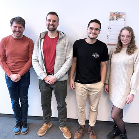 Un professionnel examine des conceptions techniques détaillées dans un espace de travail moderne.