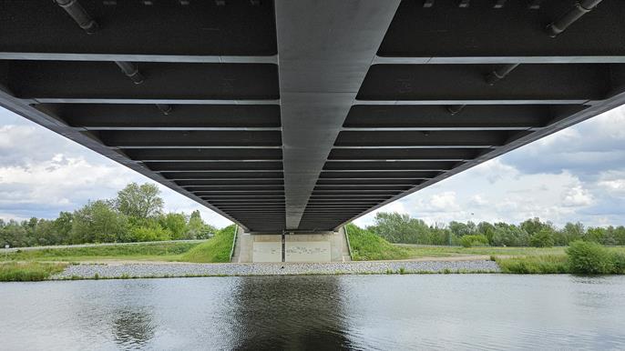 Vue de dessous du pont du Kuhdammweg à Wustermark, mettant en valeur la structure en acier