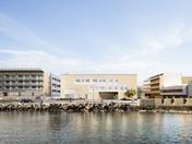 Le projet intègre de la pierre locale, des accès en terrasses et des évasements dynamiques pour créer des espaces éducatifs et communautaires flexibles.