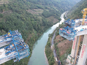 Pont en construction au-dessus de la rivière Mabian avec véhicules de lancement et nacelles suspendues