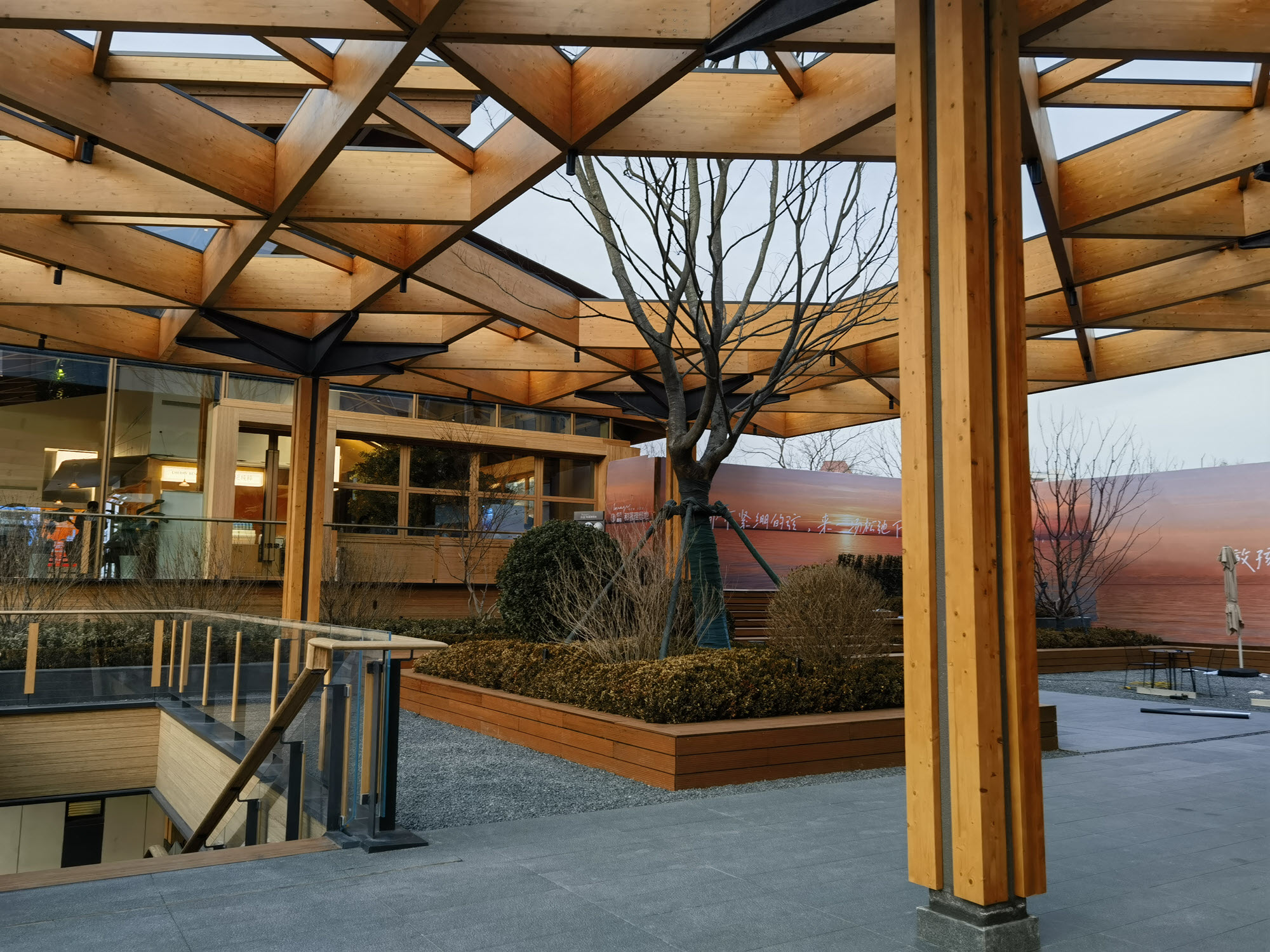 Vue de dessous de la structure de toiture en bois à l’extérieur du centre communautaire