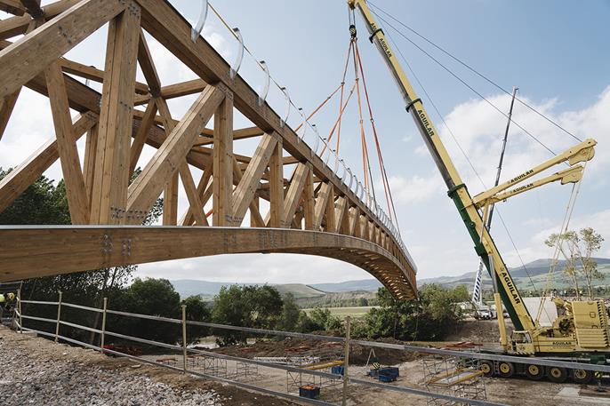Passerelle en bois en cours d’installation. Projet remarquable de construction en bois avec calcul de structure avancé.