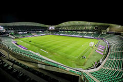 Image nocturne d’un stade impressionnant avec des lumières éclatantes mettant en évidence sa structure.