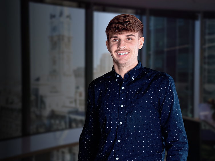 Alex Bacon dans un environnement de bureau, démontrant une présence professionnelle.