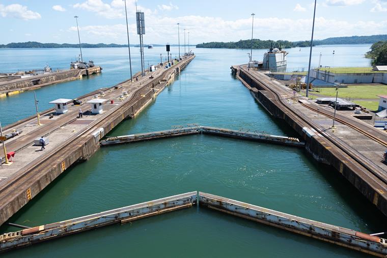 Vue du canal de Panama avec un bateau près des écluses et du paysage environnant.