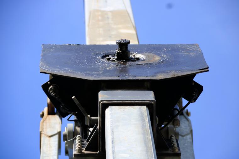 Vue détaillée d’une cheville d’attelage fixée à une plaque de maintien d’une semi-remorque.