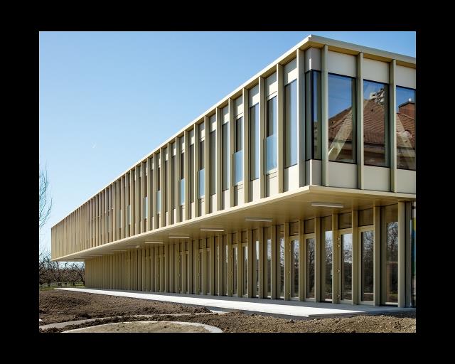 Nuovo piano superiore a sbalzo al piano terra ristrutturato dell'edificio scolastico a Sutz-Lattrigen (© Indermühle Bauingenieure)