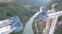 Ponte in costruzione sul fiume Mabian con carrello a sbalzo e carriole sospese