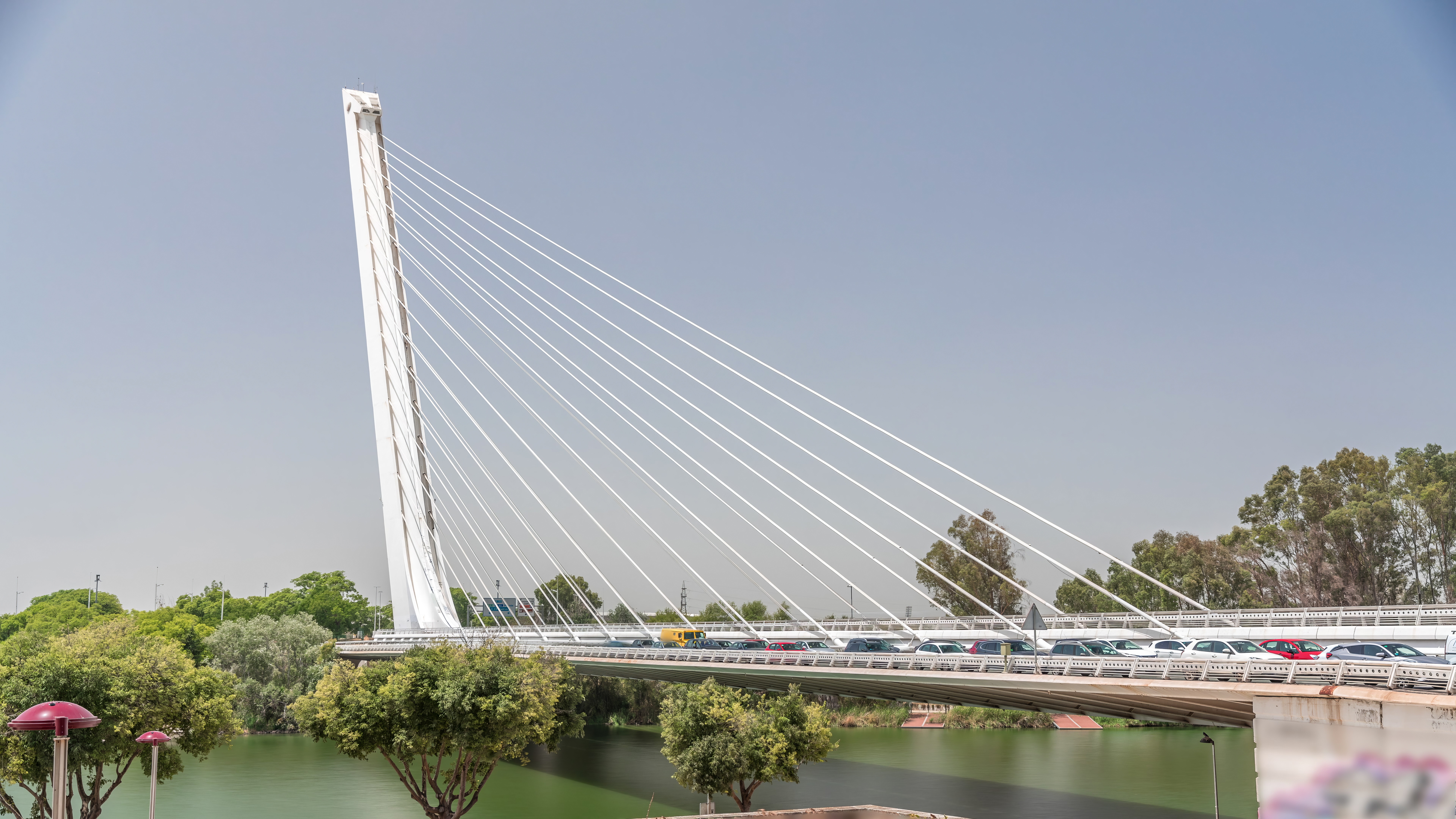 Il Puente del Alamillo di Santiago Calatrava si erige verso il cielo, circondato da acqua e nubi.