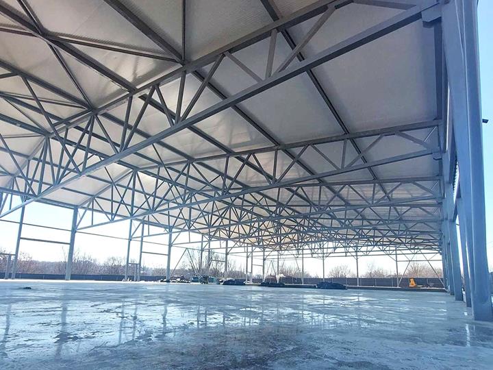 Vista dettagliata della struttura portante della copertura di un capannone con travi in acciaio e collegamenti