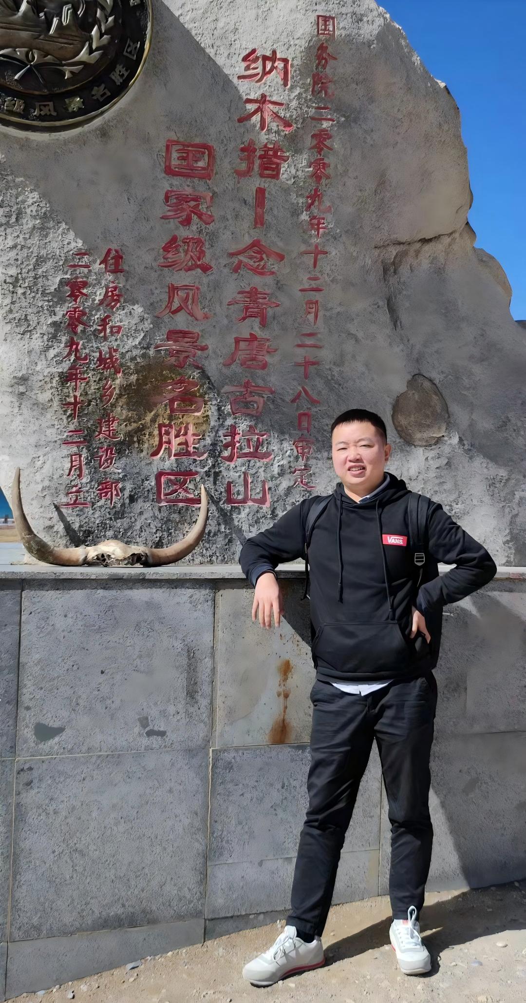 Nuova collega di Dlubal Cina in posa all'aperto davanti a un monumento in pietra con iscrizioni cinesi rosse.