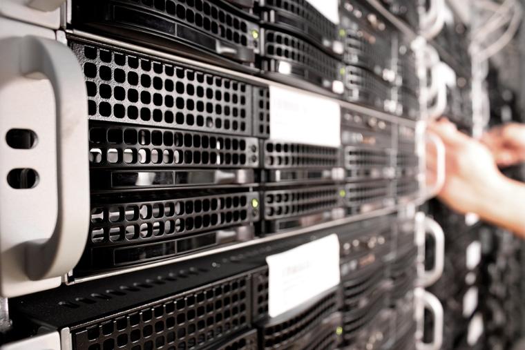 Primo piano di un rack per server con diverse unità server raffreddate tramite griglie di ventilazione, che generano un notevole calore di scarto.