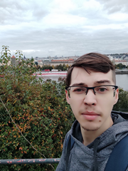 Ivan Maltsev, nuovo membro del team AI di Dlubal Software, all'aperto con un paesaggio urbano sullo sfondo.