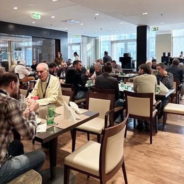 Uczestnicy rozmawiający podczas kolacji dla społeczności i wydarzenia networkingowego.