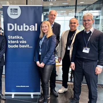 Grupa pracowników zgromadzonych na spotkaniu integracyjnym, uśmiechających się i rozmawiających ze sobą.