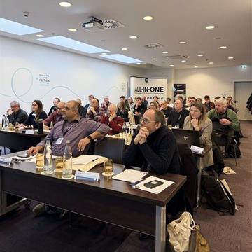 Zbliżenie technicznego ekranu prezentacyjnego z wydarzenia dotyczącego oprogramowania inżynieryjnego, pokazujące szczegółowe dane projektowe i kolorowe diagramy dotyczące analizy statyczno-wytrzymałościowej.